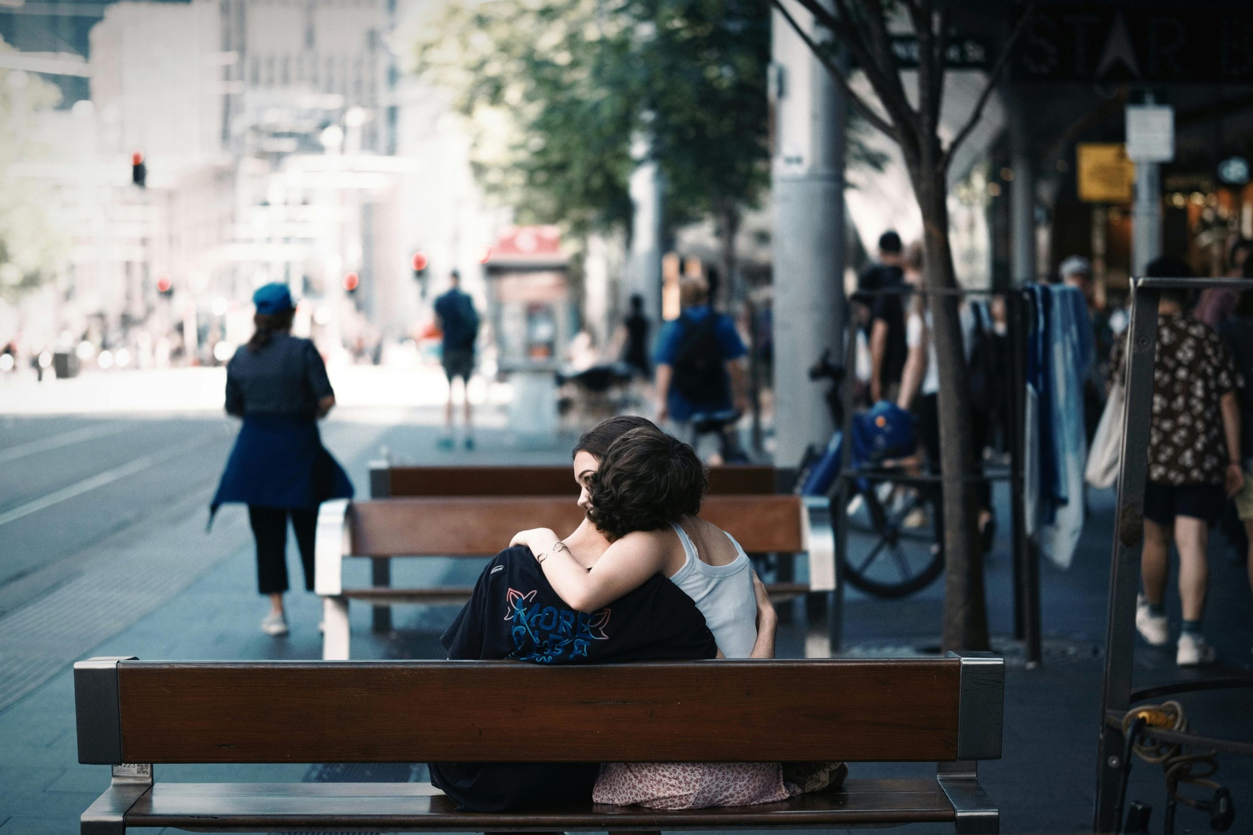 A couple shares an affectionate embrace on a bench in Sydney